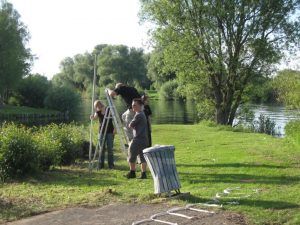 Menschen arbeiten gemeinsam am Flussufer mit Leiter
