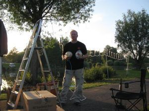 Mann im Freien mit Leiter und Kartons