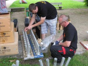 Zwei Männer bereiten Feuerwerkskörper auf Wiese vor