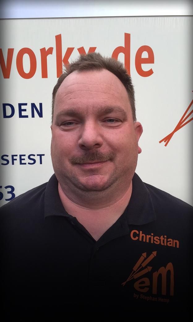 Mann mit schwarzem Polohemd vor Werbetafel