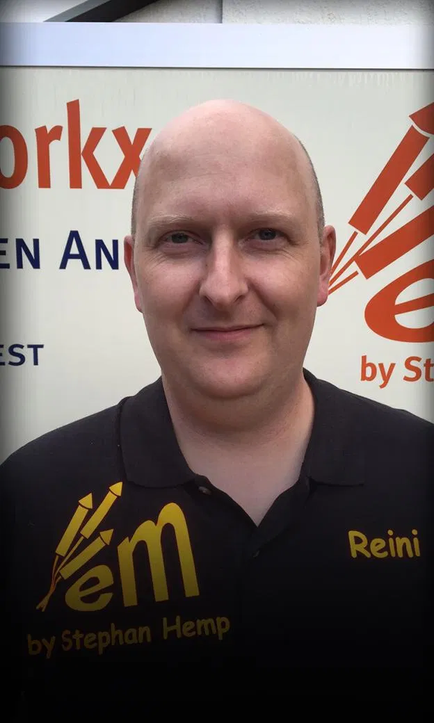 Mann mit schwarzem Shirt vor Werbetafel