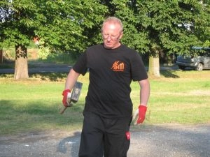 Mann im Freien mit Hammer und Handschuhen