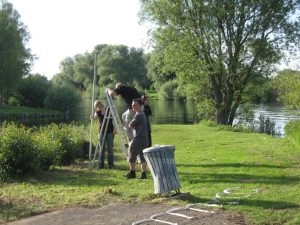 Menschen arbeiten gemeinsam am Flussufer mit Leiter