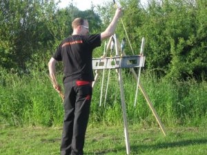 Person zündet Feuerwerksraketen im Grünen