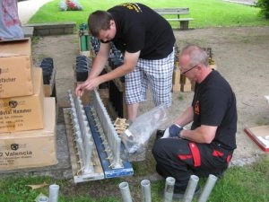 Zwei Männer bereiten Feuerwerkskörper auf Wiese vor